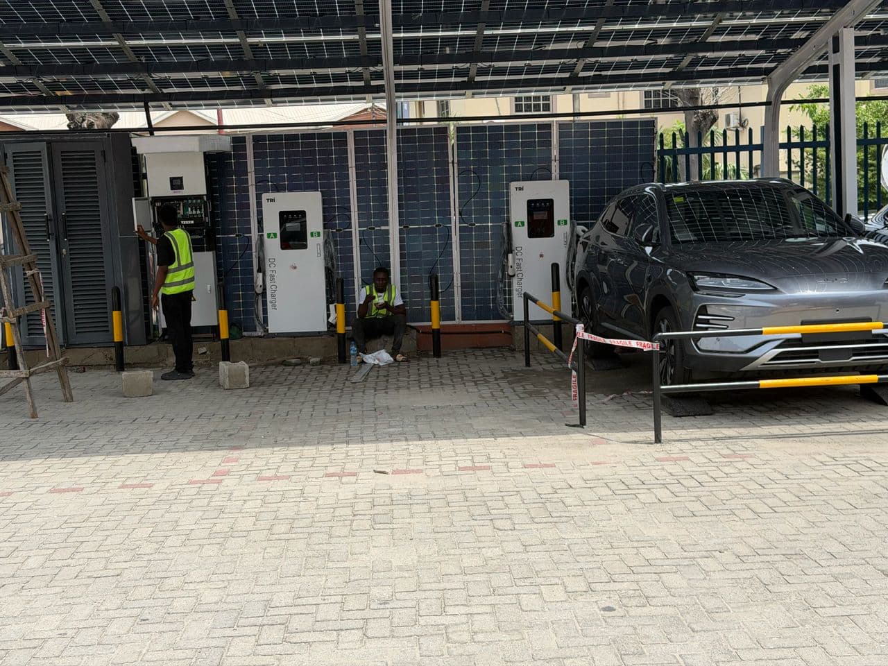 Blue Point engineers commissioning DC fast chargers beneath a solar canopy